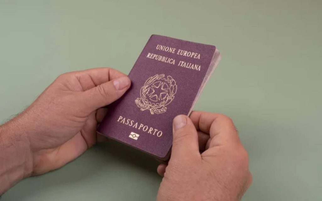 Illustrazione di una persona mentre tiene il Passaporto in mano (Depositphotos FOTO)