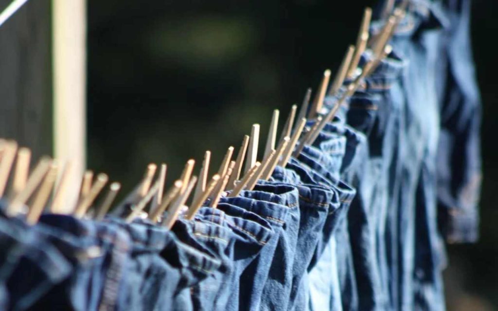 Un bel po' di jeans stesi sullo stesso filo (Pixabay)